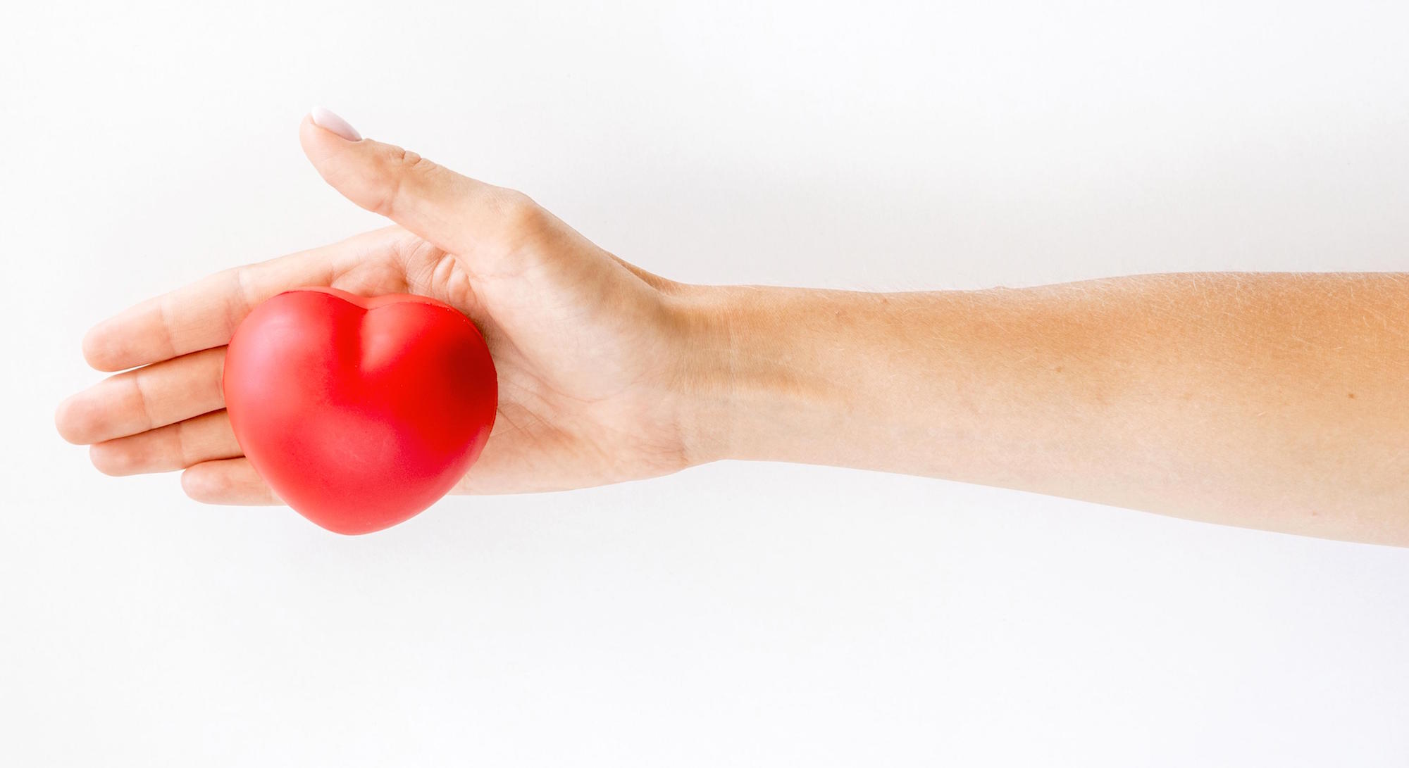 Main ouverte avec un coeur rouge - Les bienfaits de l'activité physique pour le coeur